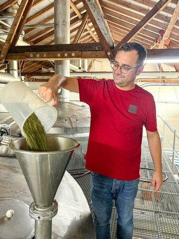 Addition of hops to the brewing process by DriveCon employee Christian Roth